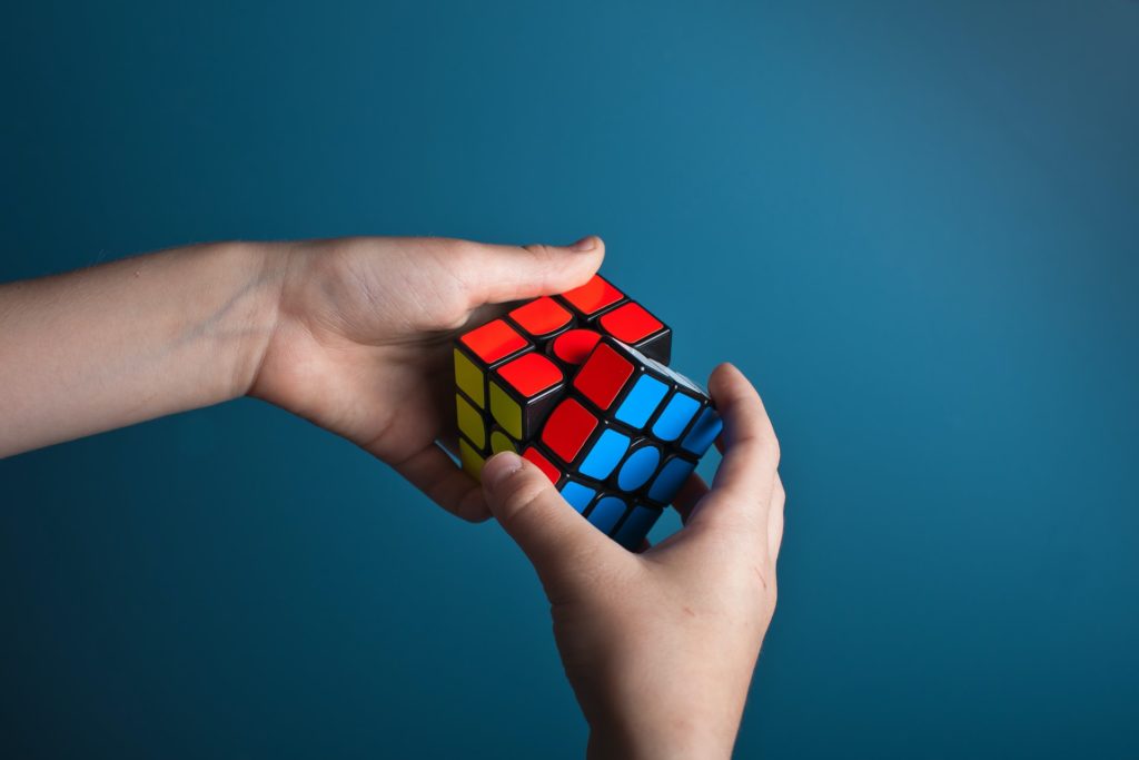 Photo of a man with rubiks cube to illustrate challenges that professionals face selling real estate
